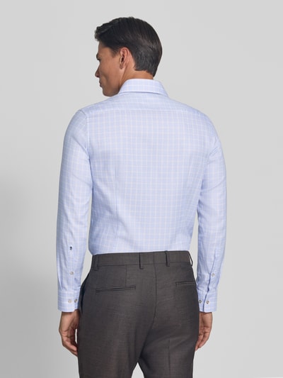 Männermodel trägt Slim Fit Businesshemd aus reiner Baumwolle von Seidensticker, hellblau kariert, glatte Textur, Ganzkörperansicht Rückansicht.