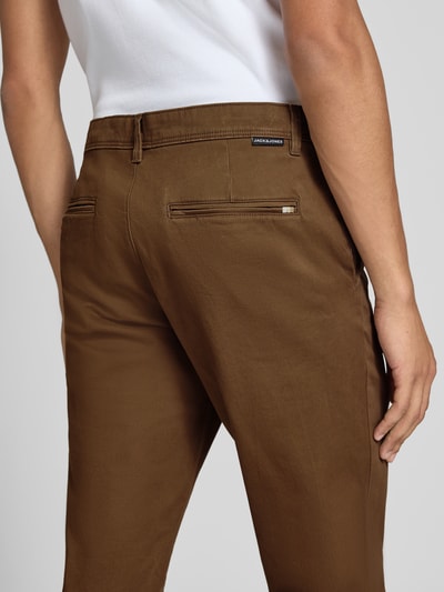 Mężczyznamodel nosi chinosy Chino mit Eingrifftaschen Modell 'MARCO' od JACK & JONES, brązowy kolor, gładka struktura, Długość wewnętrzna nogawki 77 cm, Szerokość w rozmiarze 32/32: 42 cm, wpuszczane kieszenie z tyłu, Ganzkörperansicht Rückansicht