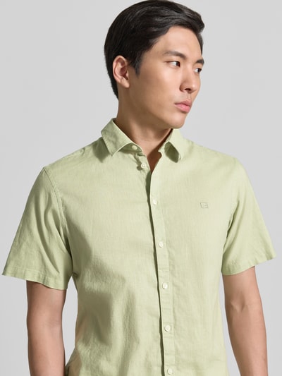 Männermodel trägt Slim Fit Freizeithemd aus Leinen-Baumwoll-Mix Modell 'AKSEL' von Casual Friday, hellgrün, Nahaufnahme Oberkörper, Kentkragen, Label-Stitching, Knopfleiste, Rückenlänge bei Größe M 78 cm, Schulterbreite 45 cm, Ärmellänge 27 cm