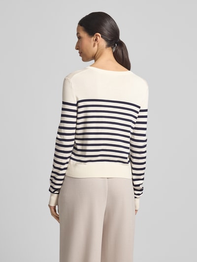 Frauenmodel trägt Strickjacke aus Viskose-Mix mit Streifenmuster von Christian Berg Woman in Creme und Dunkelblau, Ganzkörperansicht Rückansicht. Regular Fit, Rundhalsausschnitt, Knopfleiste, Rückenlänge 49 cm, Ärmellänge 61 cm.