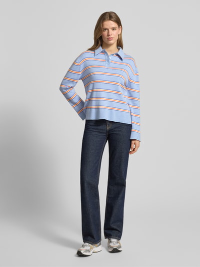 Vrouwenmodel draagt Regular Fit Poloshirt met viscose van Gina Tricot in materiaalmix met tricotlook, polokraag, met lange mouwen, ganzekijk van voren