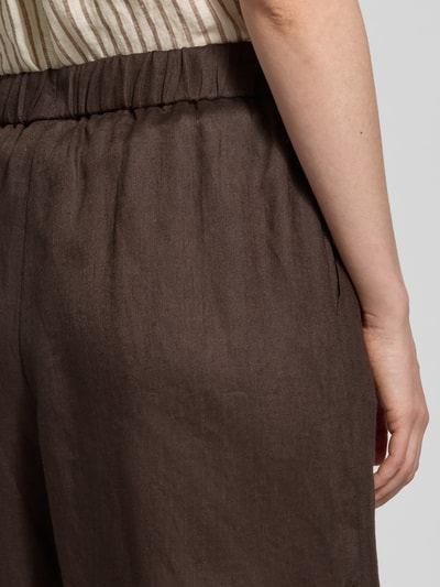 Frauenmodel trägt Culotte aus Leinen mit elastischem Bund Modell 'CANNETI' von MM by Max Mara in Dunkelbraun, Nahaufnahme Hüfte, Wide Leg Fit, französische Eingrifftaschen, reine Leinenstruktur
