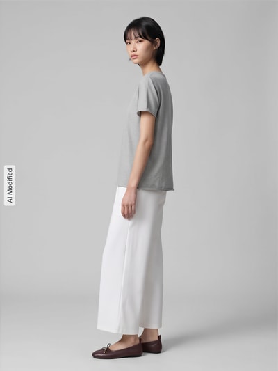 Frauenmodel trägt Stoffhose mit Eingrifftaschen von ICHI, lockere Passform, unifarben, elastischer Bund, Seitenansicht, KI-modifiziertes Bild.