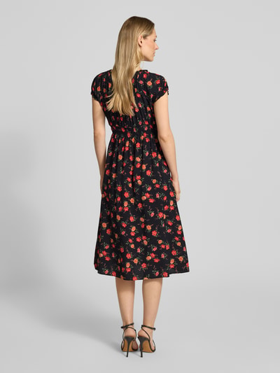 Frauenmodel trägt Midikleid aus Viskose mit Karree-Ausschnitt von Apricot, schwarz mit rotem Blumenmuster, Rückansicht, taillierte Passform, Puffärmel, Raffungen, Rückenlänge 110 cm, Brustweite 37 cm, Ärmellänge 11 cm. Ganzkörperansicht Rückansicht.