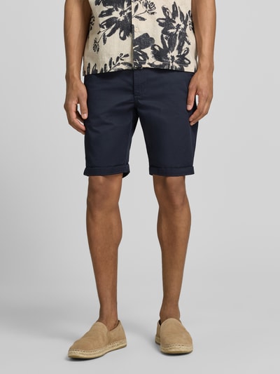 Männermodel trägt Bermudas mit Gürtel und Eingrifftaschen von MCNEAL, dunkelblau, gerader Schnitt, Baumwoll-Mix, Ganzkörperansicht von vorne.
