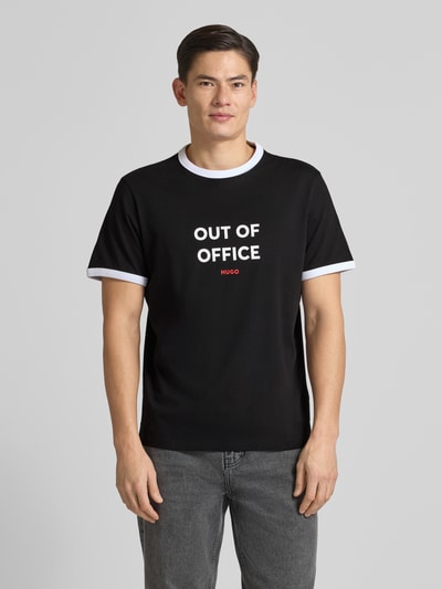 Männermodel trägt Regular Fit T-Shirt aus reiner Baumwolle Modell 'DOFFICE' von HUGO, unifarben, Label-Print, Rundhals, Kurzarm, Ganzkörperansicht von vorne.