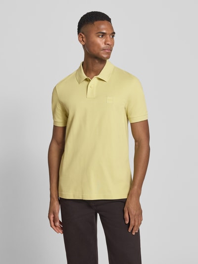Männermodel trägt Regular Fit Poloshirt aus Baumwoll-Mix Modell 'PASSENGER' von BOSS Orange, unifarben, Kurzarm, Ganzkörperansicht von vorne.