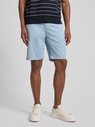 Männermodel trägt Tapered Chinoshorts aus Baumwoll-Mix von BOSS Orange in Hellblau, 5-Pocket-Design, Twill, Label Patch, Ganzkörperansicht von vorne.