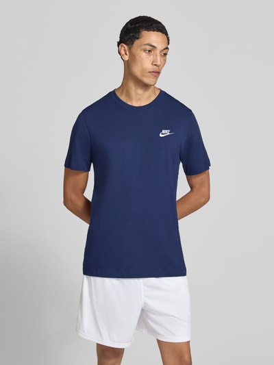 Männermodel trägt Regular Fit T-Shirt aus reiner Baumwolle von Nike in Dunkelblau mit Rundhalsausschnitt, Ganzkörperansicht von vorne. Herren T-Shirt von Nike