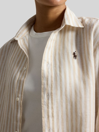 Frauenmodel trägt Boxy Fit Leinenbluse mit Allover-Muster von Polo Ralph Lauren, gestreift in Beige und Weiß, Logo-Stitching, Nahaufnahme Oberkörper.