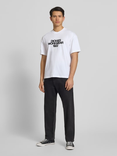 Männermodel trägt Herren T-Shirt mit Label-Print Modell 'TORREY' von Dickies in Weiß, Reine Baumwolle, Regular-Fit, Rundhalsausschnitt, Ganzkörperansicht von vorne.