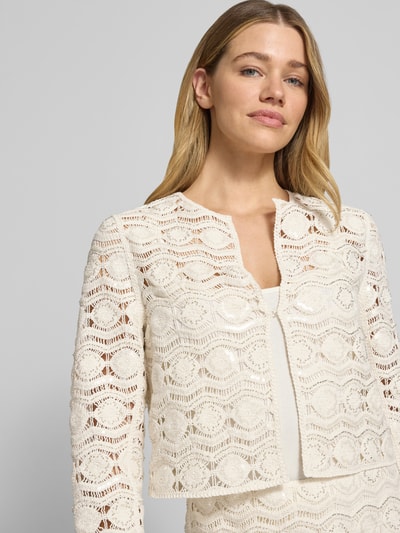 Frauenmodel trägt Blazer aus Häkelspitze mit Knopfverschluss von Marc Cain in Creme, Baumwoll-Mix mit Stretch-Anteil, Gerader-Schnitt, Nahaufnahme Oberkörper.