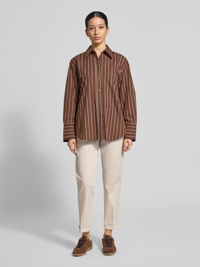 Frauenmodel trägt Chino mit Eingrifftaschen von MAC in Beige, Baumwoll-Elasthan-Mix, Regular Fit, kombiniert mit gestreiftem Hemd, Ganzkörperansicht von vorne.