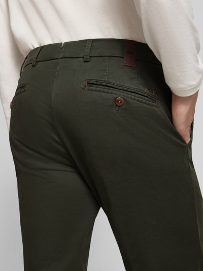 Männermodel trägt dunkelgrüne Regular Fit Chino aus Baumwoll-Mix Modell 'Lupus' von MMX mit sichtbaren Gesäßtaschen, Nahaufnahme Rückansicht, Herren Chino.