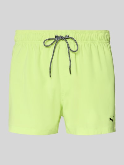 Produktfoto, Badehose mit Seitentaschen und Klettverschlusstasche hinten von PUMA in Neon-Gelb, Regular Fit, elastischer Bund, glatte Textur.