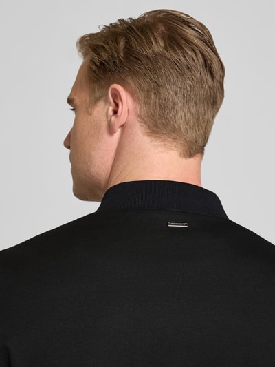 Männermodel trägt Bomberjacke mit Zweiwege-Reißverschluss von Roy Robson, schwarzer Material-Mix mit Stretch-Anteil, Nahaufnahme Rückansicht. Rückenlänge 68 cm, Schulterbreite 49 cm, Brustweite 52 cm, Ärmellänge 68 cm, Regular-Fit, Stehkragen.