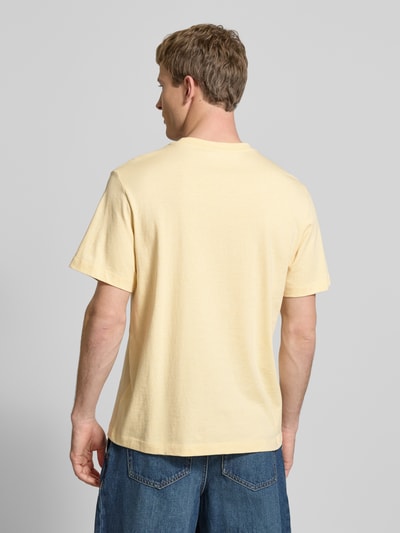 Männermodel trägt T-Shirt mit Label-Print und Rundhalsausschnitt von Calvin Klein Jeans in Gelb, Reine Baumwolle, Regular-Fit, Ganzkörperansicht Rückansicht.