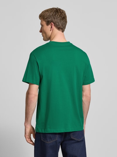 Männermodel trägt Herren T-Shirt mit Label-Print und Rundhalsausschnitt von Calvin Klein Jeans in Grün, reine Baumwolle, Regular-Fit, Rückenlänge 70 cm, Ganzkörperansicht Rückansicht.