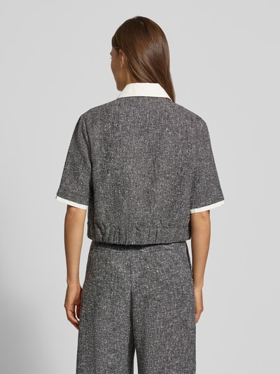 Vrouwenmodel draagt Cropped Bluse mit Brusttaschen Modell 'LINO' van SUNCOO PARIS, Materiaalmix met viscose, korte look, overhemdkraag, knoopsluiting, borstzakken, ruglengte maat S 49 cm, mouwlengte maat S 28 cm, grijstonen met witte details, gestructureerde textuur, Ganzkörperansicht Rückansicht.