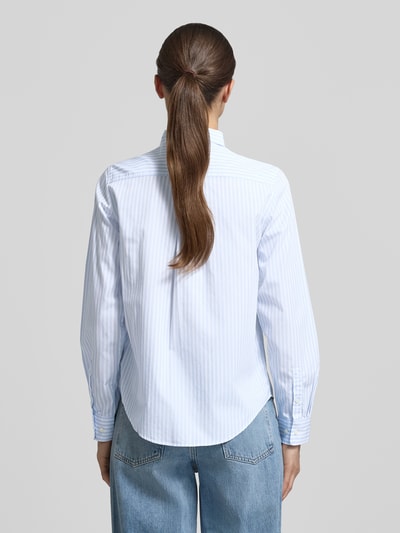 Modelka kobieca ma na sobie Regular Fit Bluse mit Streifenmuster und Label-Stitching od Gant, bawełna, krój regular fit, wzór w paski, kołnierzyk koszulowy, haft z logo, długość tyłu w rozmiarze 36: 65 cm, długość rękawa w rozmiarze 36: 61 cm, jasnoniebieskie i białe paski, gładka tekstura, widok całej sylwetki z tyłu.