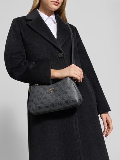 Frauenmodel trägt Shoulder Bag mit Steckfach Modell 'NOELLE' von GUESS mit Allover-Logo-Muster, Detailaufnahme Oberkörper.