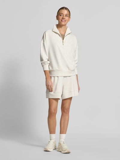 Frauenmodel trägt Shorts mit elastischem Bund Modell 'alder' von VARLEY aus Viskose-Mix mit Stretch-Anteil, High-Rise Fit, Kordelzug, cremefarben, glatte Textur, Damen Shorts, Ganzkörperansicht von vorne.