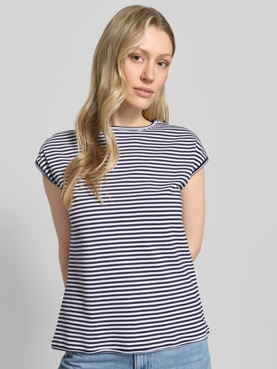 Frauenmodel trägt T-Shirt mit Rundhalsausschnitt von Christian Berg Woman aus Reine Baumwolle, Regular-Fit, Rollsaum, Rückenlänge 55 cm, Ganzkörperansicht von vorne.