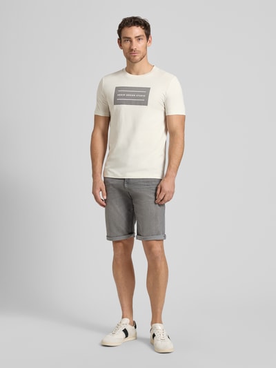 Männermodel trägt Regular Fit T-Shirt aus reiner Baumwolle von Tom Tailor Denim, unifarben, Label-Schriftzug, Ganzkörperansicht von vorne.