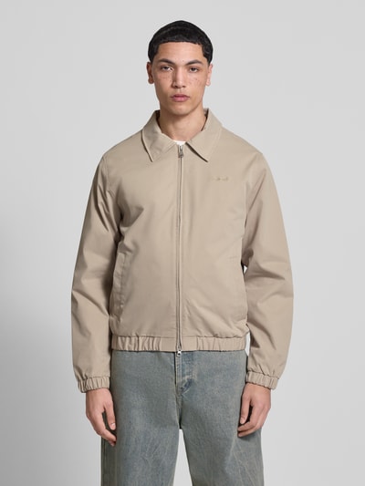 Männermodel trägt Jacke mit Zweiwege-Reißverschluss Modell 'CATSKILLS' von Jack & Jones in Beige, Regular Fit, Umlegekragen, Ganzkörperansicht von vorne.