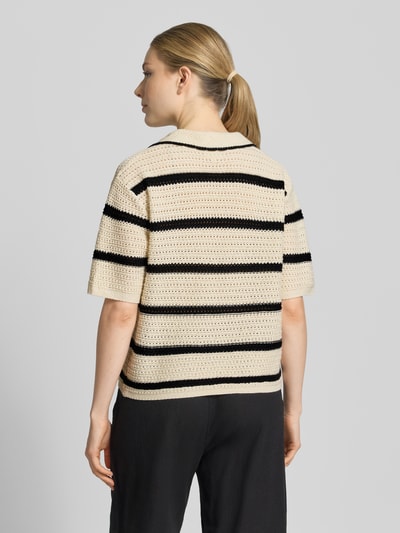 Frauenmodel trägt Regular Fit Poloshirt aus Baumwoll-Mix von s.Oliver RED LABEL, gestreift in Beige und Schwarz, Strickoptik, kurze Ärmel, Ganzkörperansicht Rückansicht.