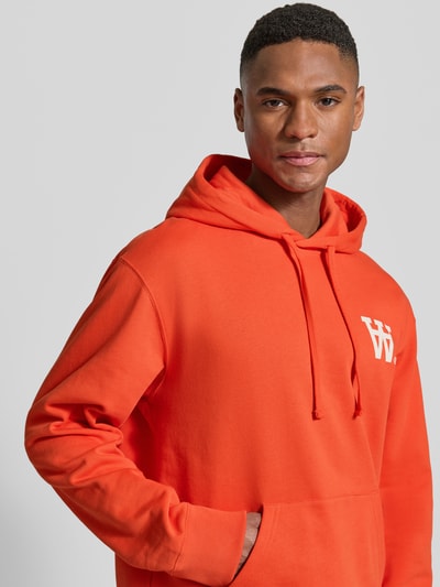 Mannelijk model draagt Hoodie met Logo-Print en Känguru-Tasche van Wood Wood in feloranje, katoen, loose fit, Nahaufnahme bovenlichaam