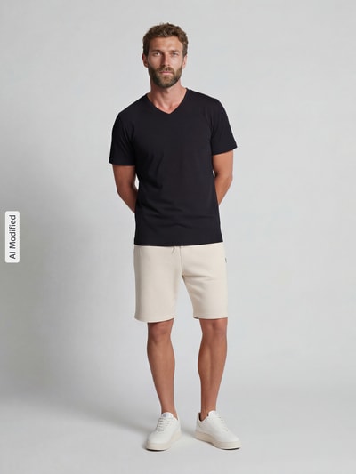 Männermodel trägt T-Shirt mit V-Ausschnitt von Christian Berg Men in Schwarz, reine Baumwolle, gerader Schnitt, Ganzkörperansicht von vorne.