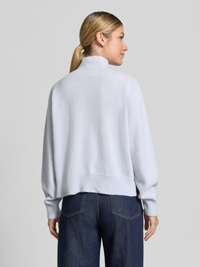 Vrouwenmodel draagt gebreide pullover met opstaande kraag Model 'LYZIMA' van DRYKORN, puur katoen, regular fit, ruglengte maat S 51 cm, mouwlengte maat S 61 cm, denim broek, Ganzkörperansicht Rückansicht.