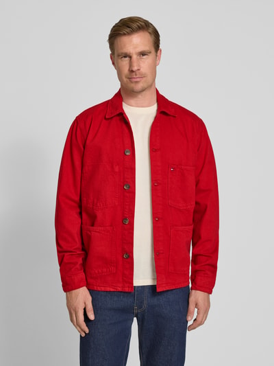 Männermodel trägt Regular Fit Hemdjacke aus reiner Baumwolle von Tommy Hilfiger in Rot, unifarben, Rigid Denim, Ganzkörperansicht von vorne.