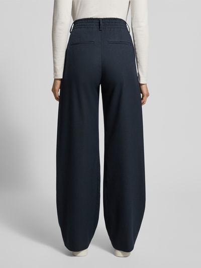 Vrouwenmodel draagt Hose mit Gesäßtaschen Modell 'JEALOUS' van Drykorn, donkerblauw, wijde pijpen, zichtbare achterzakken, fullbody achteraanzicht, materiaal-mix met viscose.
