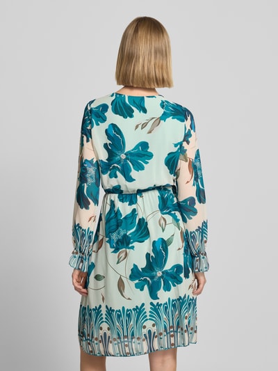 Frauenmodel trägt knielanges Kleid im Allover-Look Modell 'Ja44milaa' von ZABAIONE aus hellblauem Chiffon mit floralen Mustern, Ganzkörperansicht Rückansicht.