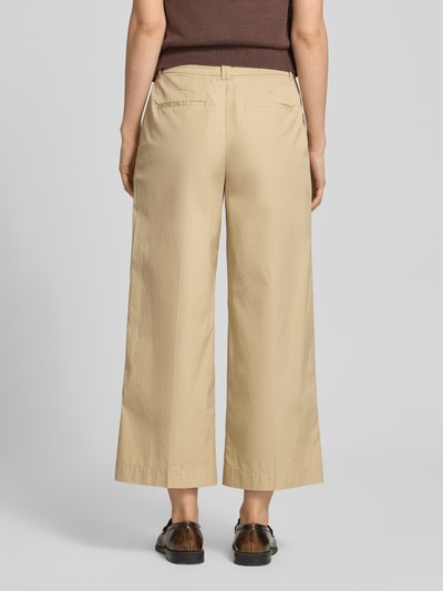 Frauenmodel trägt Hose in verkürzter Passform mit Eingrifftaschen von Gant aus Reine Baumwolle, Paspeltaschen am Gesäß, Ganzkörperansicht Rückansicht.