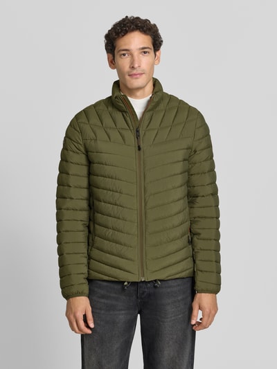 Männermodel trägt Steppjacke mit Label-Patch Modell 'LAPAZ' von Napapijri in Olivgrün, Reißverschluss, Seitentaschen, Ganzkörperansicht von vorne.