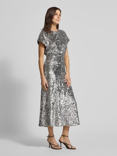 Vrouwenmodel draagt Maxikleid met Pailletten- en Ziersteinbesatz van Rich & Royal, elastische materiaalmix, getailleerd, ronde hals, met korte mouwen, maxilengte, zilveren kleur, naadritssluiting op de rug, ruglengte maat 36: 135 cm, borstwijdte 48 cm, mouwlengte 23 cm, textuur glanzend en glinsterend, Ganzkörperansicht van voren.