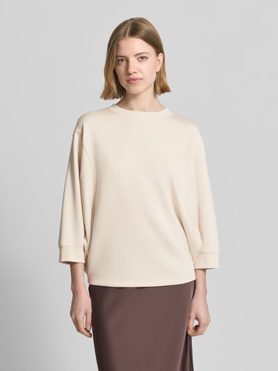 Vrouwenmodel draagt 'Sweatshirt mit Rundhalsausschnitt und 3/4-Arm' van comma, beige katoen-elastaanmix, relaxed fit, vooraanzicht bustenclose-up.