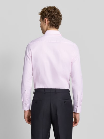 Männermodel trägt Slim Fit Businesshemd aus reiner Baumwolle Modell 'New Kent' von Seidensticker in Hellrosa, Ganzkörperansicht Rückansicht. Herren Businesshemd von Seidensticker.