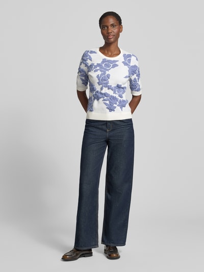 Frauenmodel trägt Strickpullover im Allover-Look mit 1/2-Arm von Christian Berg Woman, weiß-blau, Material-Mix mit Viskose-Anteil, Slim-Fit, Rundhalsausschnitt, Ganzkörperansicht von vorne.