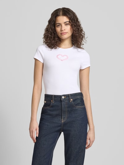 Frauenmodel trägt weißes T-Shirt mit Rundhalsausschnitt Modell 'PREPPY HEART' von Review aus Baumwoll-Mix, gerader Schnitt, Feinripp, Ganzkörperansicht von vorne.