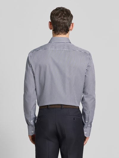 Männermodel trägt Regular Fit Businesshemd mit extra langem Arm Modell 'H-JOE-K' von BOSS aus reiner Baumwolle, Optik:Allover-Muster, gestreift, Ganzkörperansicht Rückansicht.