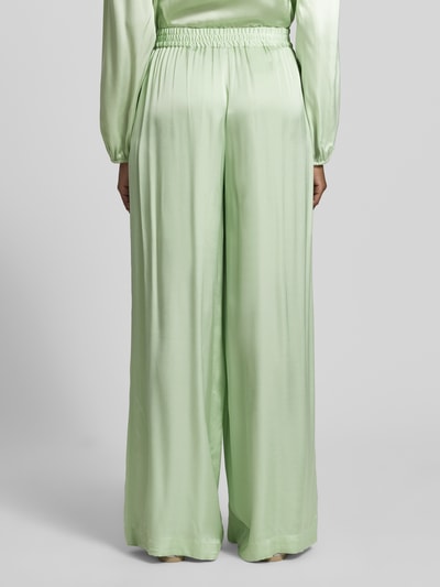 Frauenmodel trägt Regular Fit Wide Leg Hose aus reiner Viskose Modell 'TALIA' von BOSS Orange in Optik: Unifarben, Satin, Relaxed-Fit, Ganzkörperansicht Rückansicht.