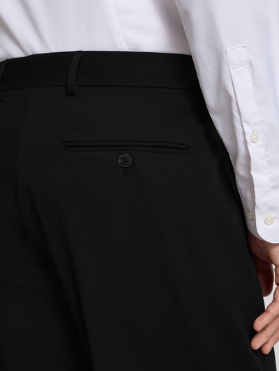 Männermodel trägt Loose Fit Anzughose mit Viskose-Anteil Modell 'LIAM' von SELECTED HOMME, Optik: Unifarben, Materialverarbeitung: Stretch, knitterfrei, seitliche Eingrifftaschen, Gesäßtaschen, Nahaufnahme Rückansicht.