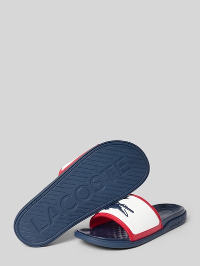Produktfoto, Badeschuhe mit Logo-Print Modell 'SERVE SLIDE 1.0' von Lacoste in Mehrfarbig-Optik, Schuhspitze Rund, Absatzform Flach, Applikation Logo-Schriftzug, Verschluss Schlupf/offen, strukturierte Sohle