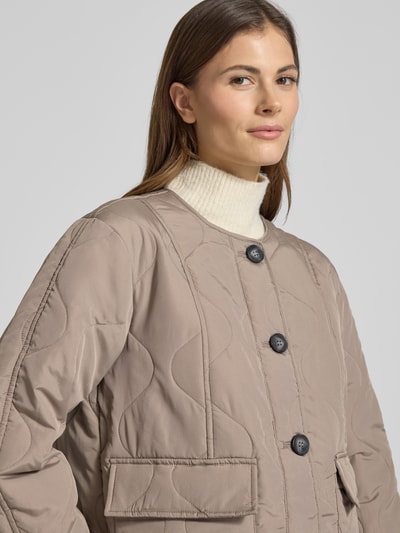 Vrouwenmodel draagt Regular Fit Steppjacke met Pattentaschen Modell 'MILLIE' van Vero Moda, unikleuren, zonder kraag, lange mouw, doorgestikte structuur, detailopname bovenlichaam.