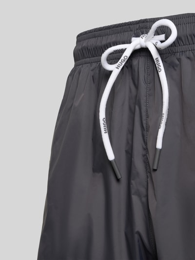 Produktfoto, Badeshorts mit Label-Print Modell 'HAITI' von HUGO, szary kolor, gładka faktura, elastyczny pas, tunelowy sznurek, boczne kieszenie, kieszeń z tyłu