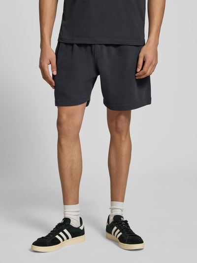 Männermodel trägt Shorts mit Logo-Stitching Modell 'ZANICA' von Ellesse aus Baumwoll-Mix, Relaxed-Fit, Seitliche Eingrifftaschen, Ganzkörperansicht von vorne.